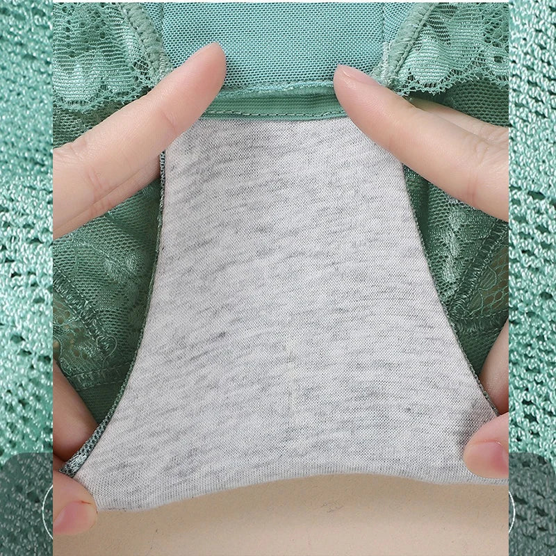 Close-up of a gray fabric patch held between two fingers against a green lace background
