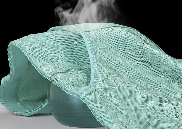 Close-up of a green lace fabric with floral patterns on a black background