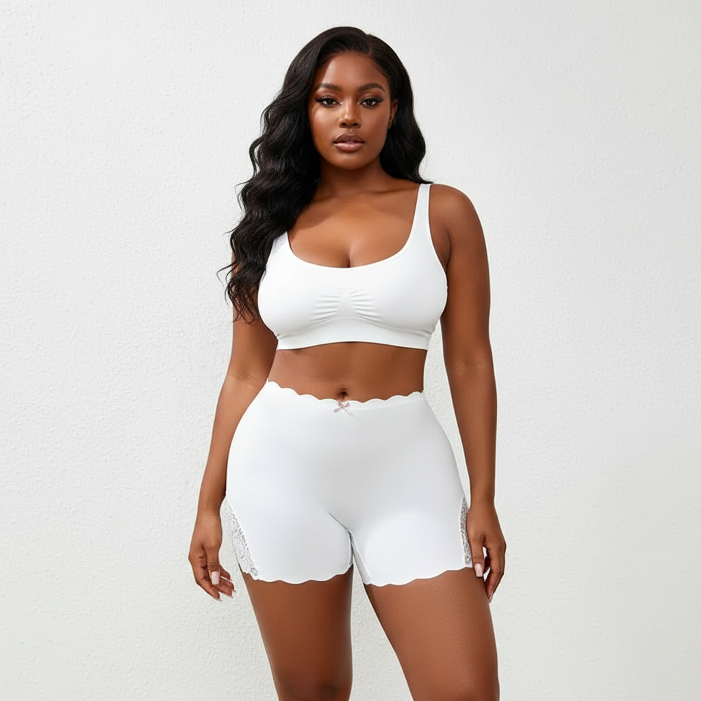 Woman wearing a white sports bra and shorts set on a plain background